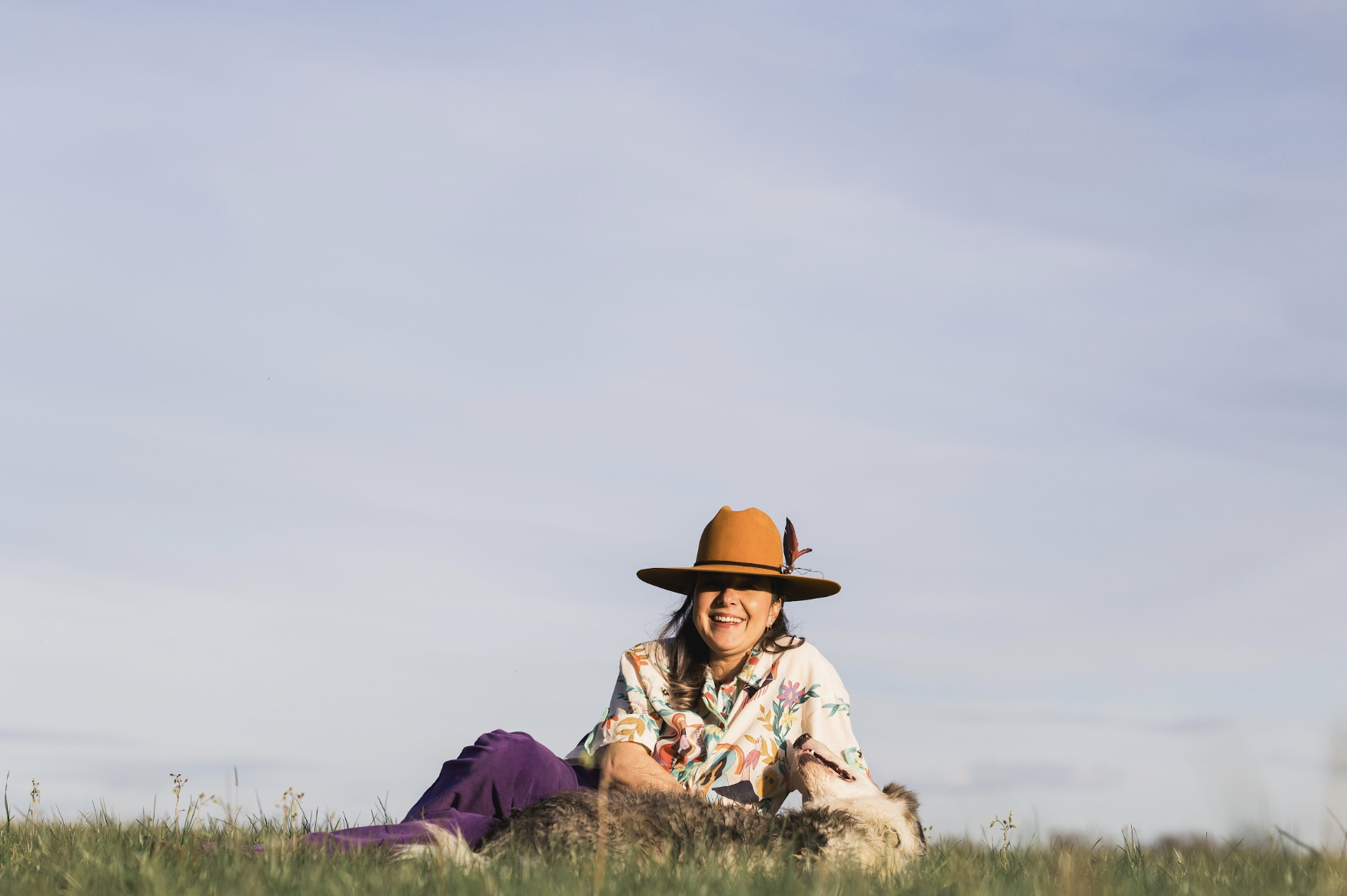 Fanny Shanka riant dans l'herbe avec son chien